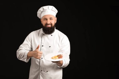 Koyu arkaplanda yakışıklı bir aşçı.