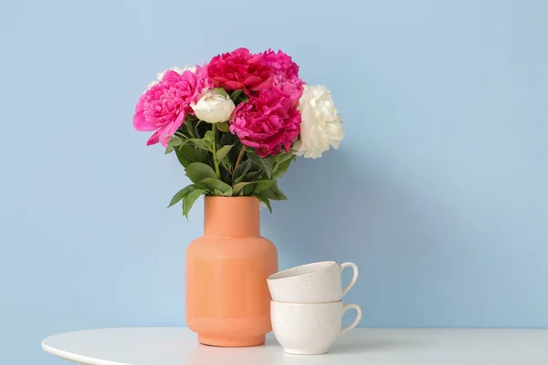 Βάζο Όμορφα Λουλούδια Παιώνια Και Φλιτζάνια Στο Τραπέζι Στο Δωμάτιο — Φωτογραφία Αρχείου