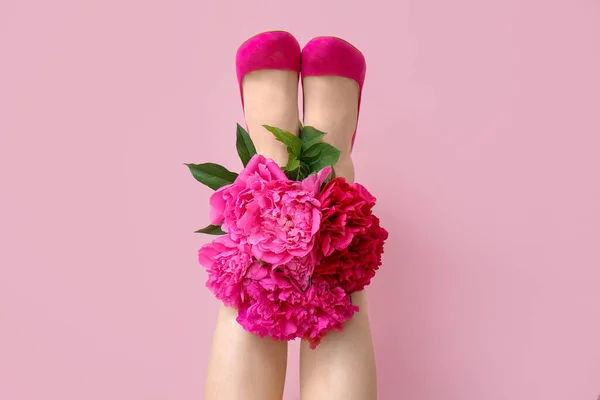 Weibliche Beine Mit Schönen Pfingstrosenblüten Auf Farbigem Hintergrund — Stockfoto