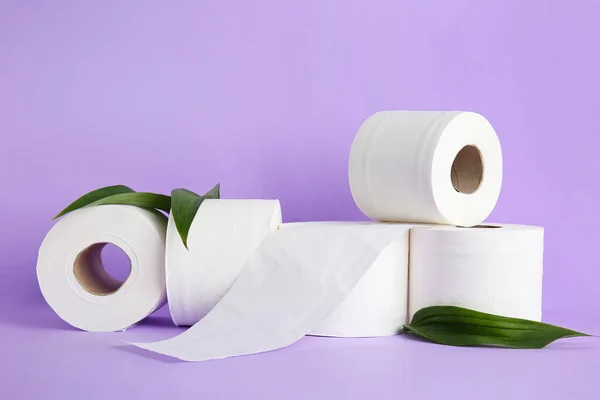 Rolls of toilet paper on color background