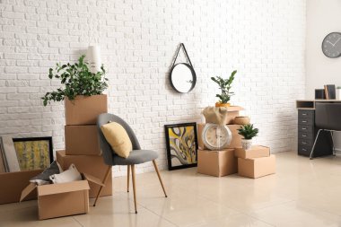 Taşındığı gün yeni dairede içinde eşyalar olan karton kutular.