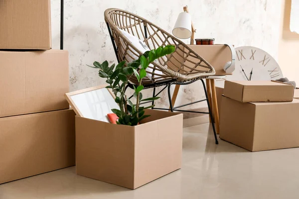 搬迁日新公寓内装有个人物品和扶手椅的纸板箱 — 图库照片
