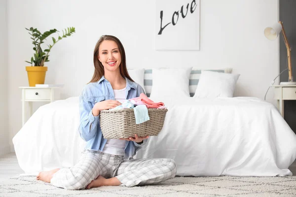 Young woman with clean laundry at home