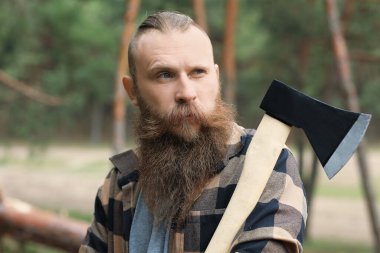 Ormanda baltası olan yakışıklı bir oduncu.