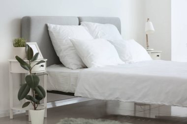 Odasında temiz çarşaf olan büyük, rahat bir yatak.