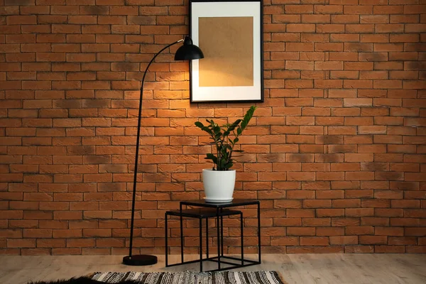 レンガの壁の近くのテーブルとランプ付きの部屋のインテリア — ストック写真