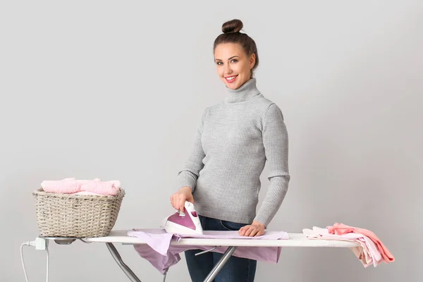 Mujer Joven Planchando Ropa Sobre Fondo Gris — Foto de Stock