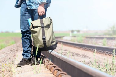 Tren raylarının yanında sırt çantalı bir kadın gezgin.