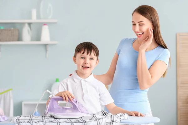 Jonge Vrouw Met Haar Zoontje Strijken Wasgoed Thuis — Stockfoto