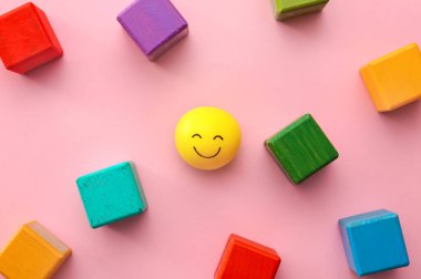 Renkli arka planda gülen yüzlü küpler ve top