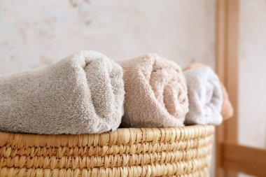 Çamaşır odasında temiz havlular olan hasır sepeti, yakın plan.