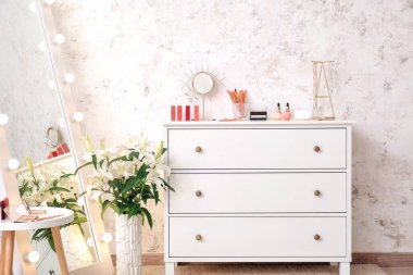 Modern soyunma odasındaki çekmecelere ayna ve makyaj kozmetikleri.