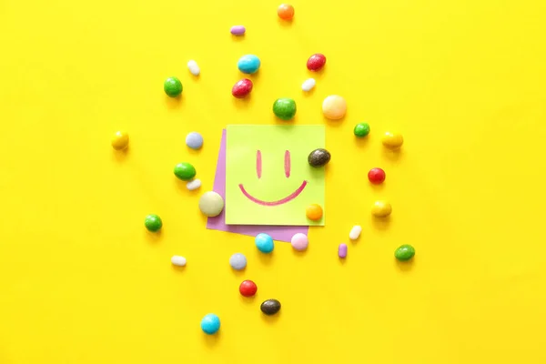 Papiere Mit Gezeichnetem Glücklichen Gesicht Und Bonbons Auf Farbigem Hintergrund — Stockfoto