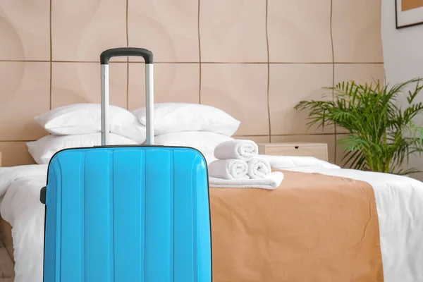 旅馆房间靠近床边的手提箱 — 图库照片