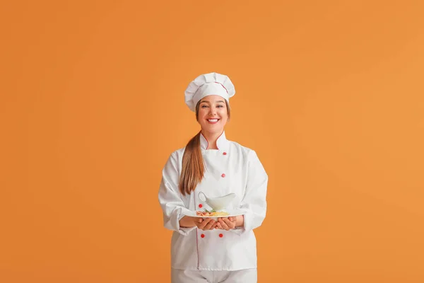 年轻的女厨师 配上色泽鲜美的菜 — 图库照片