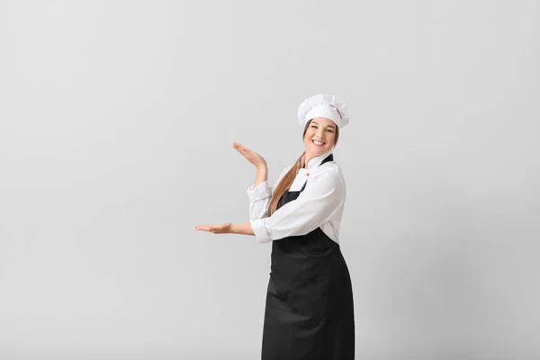 Giovane Chef Femminile Mostrando Qualcosa Sfondo Chiaro — Foto Stock