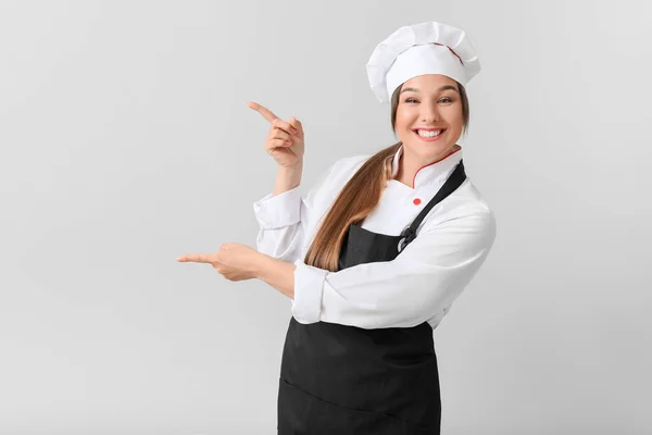 Giovane Chef Femminile Mostrando Qualcosa Sfondo Chiaro — Foto Stock