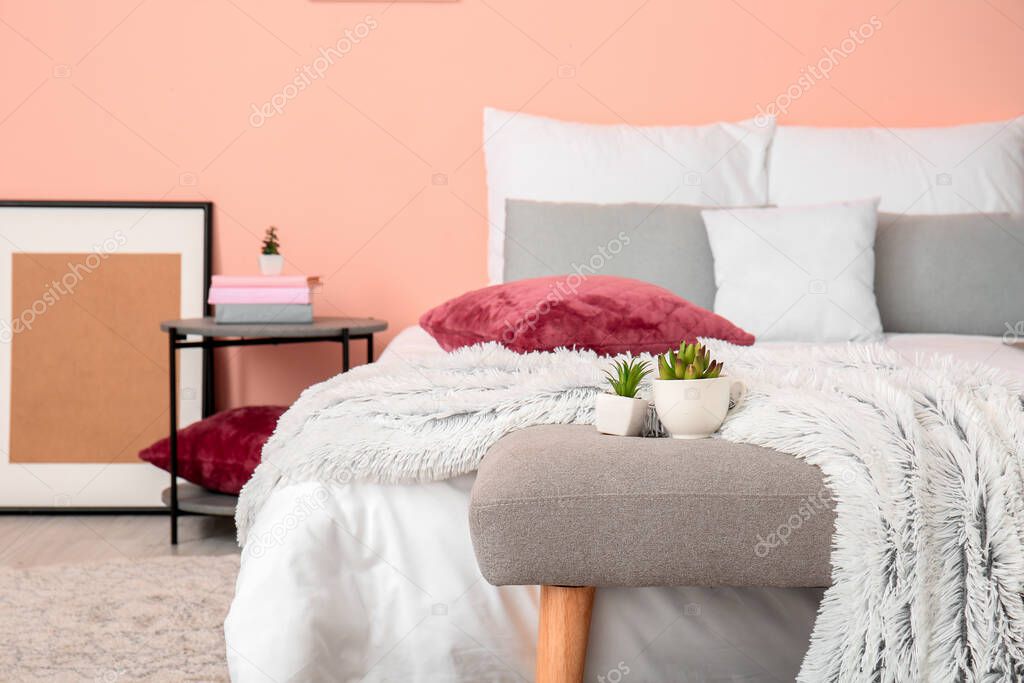 Stylish interior of room with bed and bench