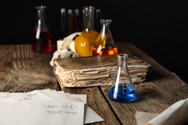 Simyacı masasında iksirler ve eski kitaplar.