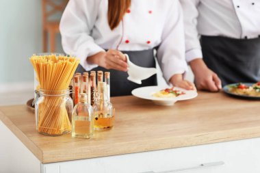 Erkek ve kadın aşçılar mutfakta yemek pişiriyor.