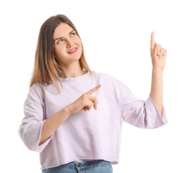 Beyaz arka planda bir şeyler gösteren güzel genç bir kadın.