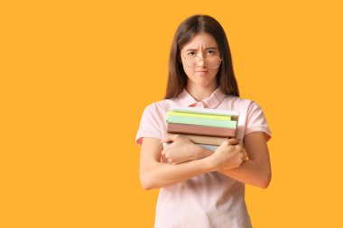 Renk arkaplanı üzerine kitapları olan stresli öğrenci