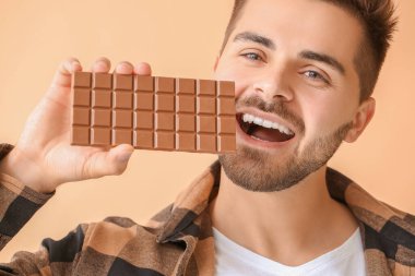 Renkli çikolatası olan yakışıklı bir genç.