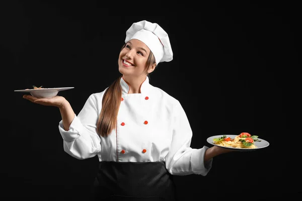 Junge Köchin Mit Schmackhaften Gerichten Auf Dunklem Hintergrund — Stockfoto