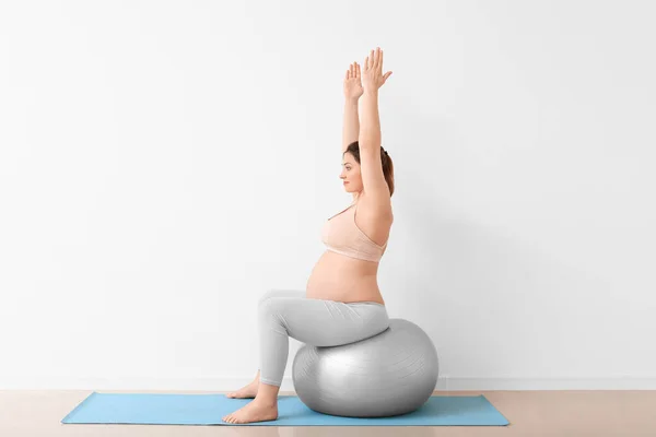 Jonge Zwangere Vrouw Training Buurt Van Lichte Muur — Stockfoto