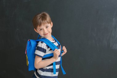 Esmer arka planda şirin bir okul çocuğu.