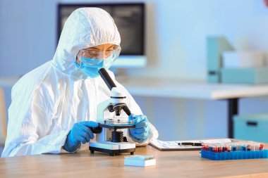 Laboratuvarda mikroskopla çalışan bilim adamı