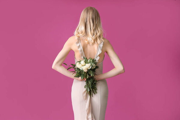 Beautiful young woman with bouquet of roses on color background