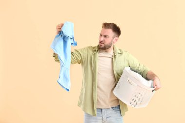 Renkli arka planda çamaşırları olan hoşnutsuz bir adam