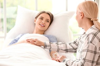 Anne kızını hastanede ziyaret ediyor.