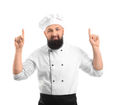 Yakışıklı erkek şef beyaz arka planda bir şeye işaret ediyor.