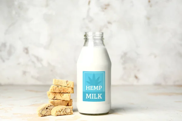 Bottle with hemp milk and cookies on table