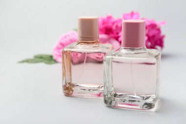 Gri arka planda çiçek parfümü şişeleri