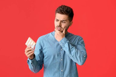 Renkli çikolatalı düşünceli bir genç adam.