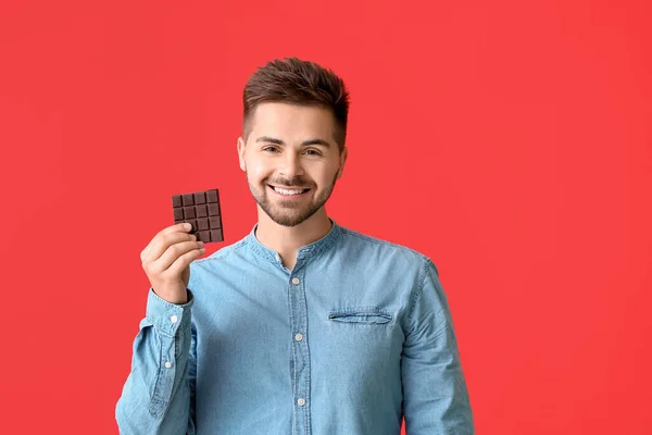 Joven Guapo Con Sabroso Chocolate Sobre Fondo Color — Foto de Stock