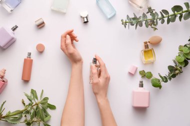 Beyaz arka planda kadın eli ve parfümleri