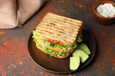 Masada lezzetli salatalıklı sandviç tabağı.