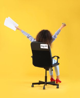 Renkli arka planda koltukta oturan mutlu iş kadını. Hafta sonu kavramı