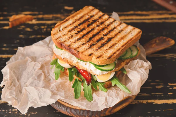 Tasty cucumber sandwich on wooden table