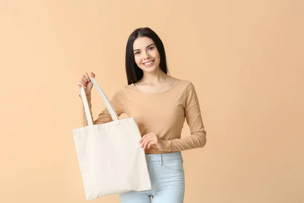 Young woman with eco bag on color background