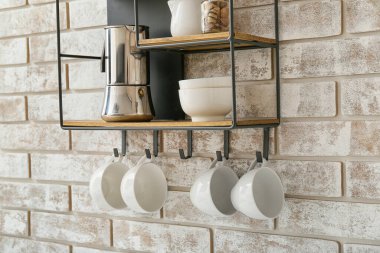 Shelf with kitchenware on brick wall clipart