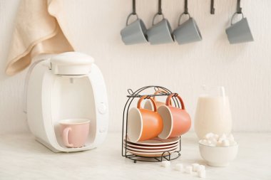 Mutfak masasında fincan ve tabakları olan tutucu.