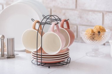 Mutfak masasında fincan ve tabakları olan tutucu.