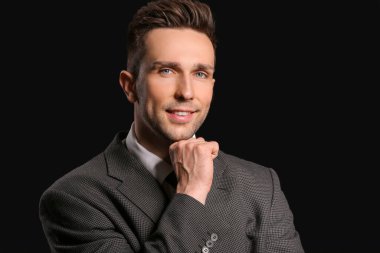 Koyu arka plan üzerinde yakışıklı işadamı portresi