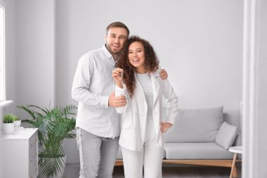 Yeni dairelerinde anahtarı olan mutlu genç bir çift.