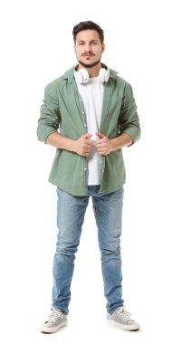 Beyaz arka planda kulaklıkları olan yakışıklı bir genç.
